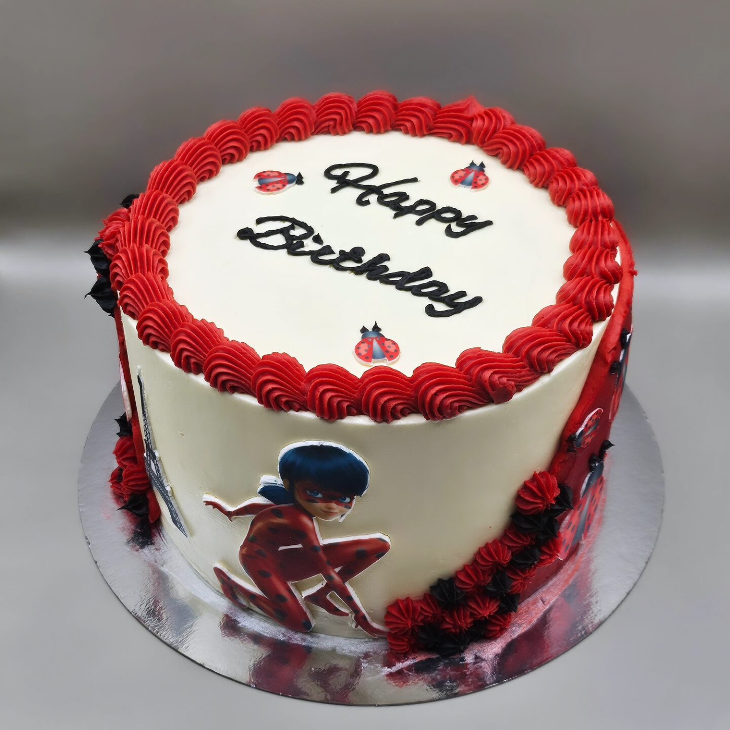 Födelsedagstårta, röd och svart med ätbar bild på en superhjälte